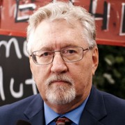 Serious older man with white hair, mustache and goatee